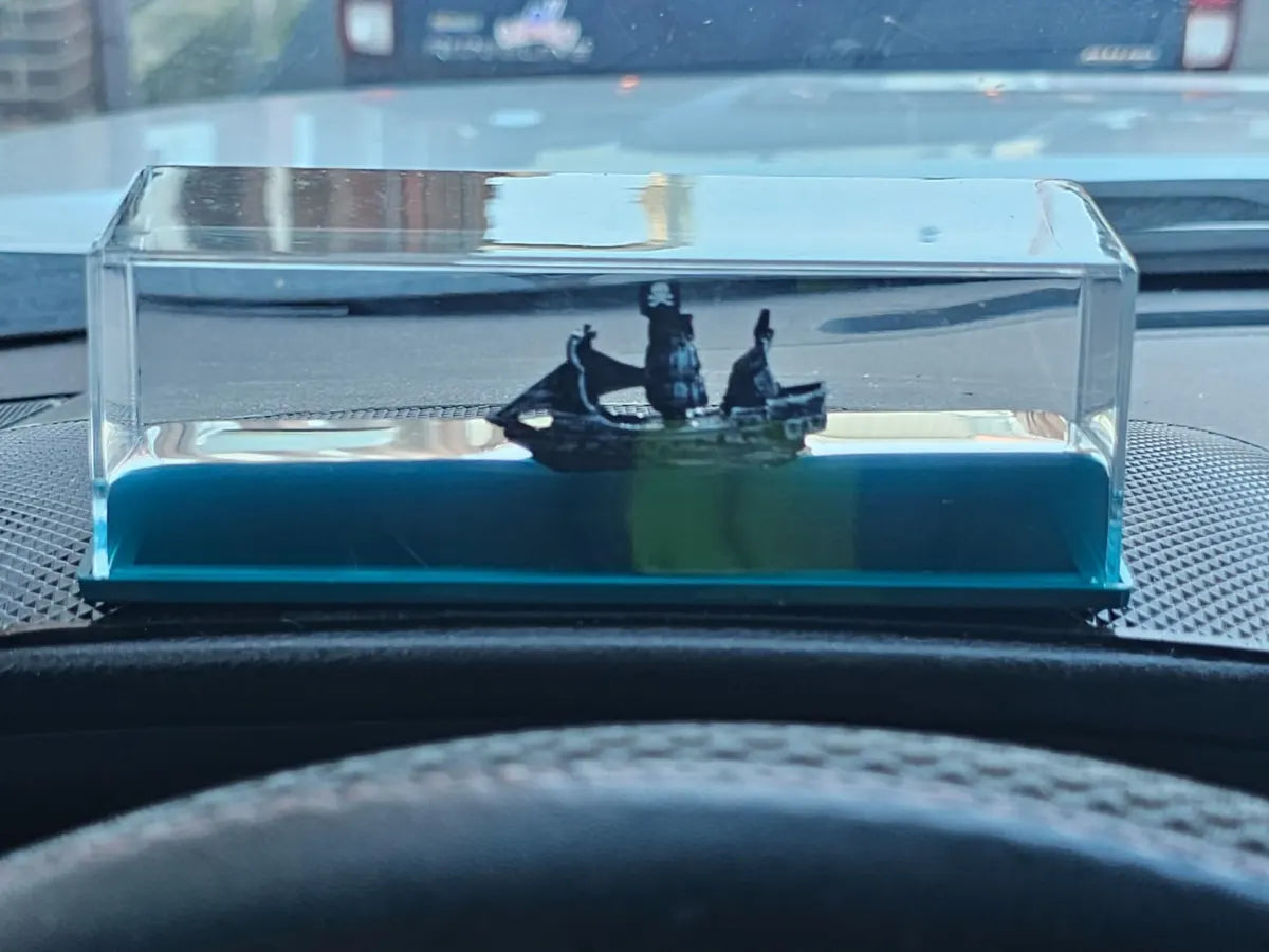 Pirate ship liquid display photographed on a dashboard